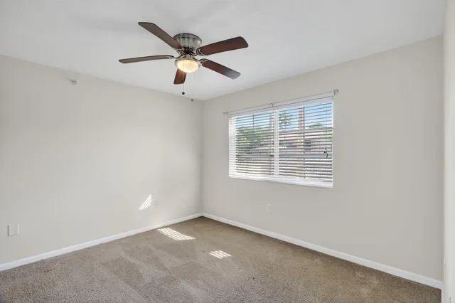 an empty room with chandelier fan