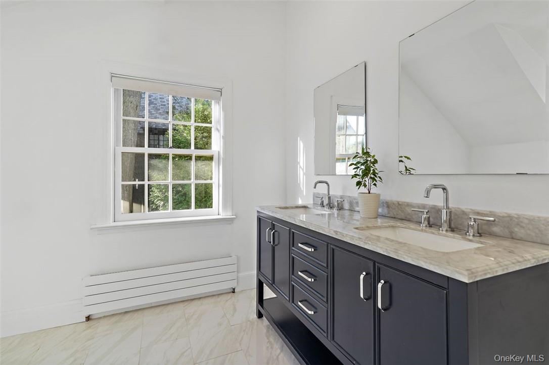 246 Mamaroneck Road Scarsdale, NY 10583 - Photo 31 of 35 Primary bathroom with dual sinks, vaulted ceiling and plenty of natural light