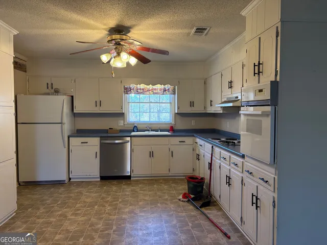 a kitchen with cabinets a window and stainless steel appliances