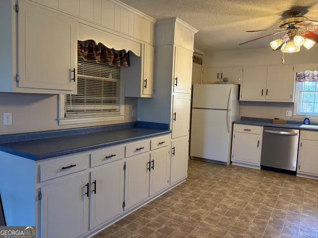 a kitchen with stainless steel appliances a refrigerator sink and cabinets