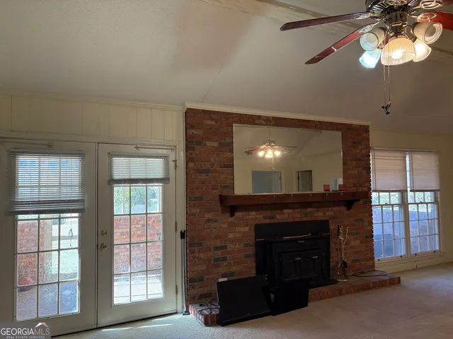 a living room with furniture a fireplace and a large window
