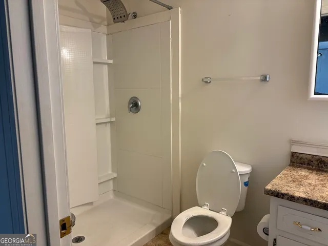 a bathroom with a granite countertop toilet and a sink
