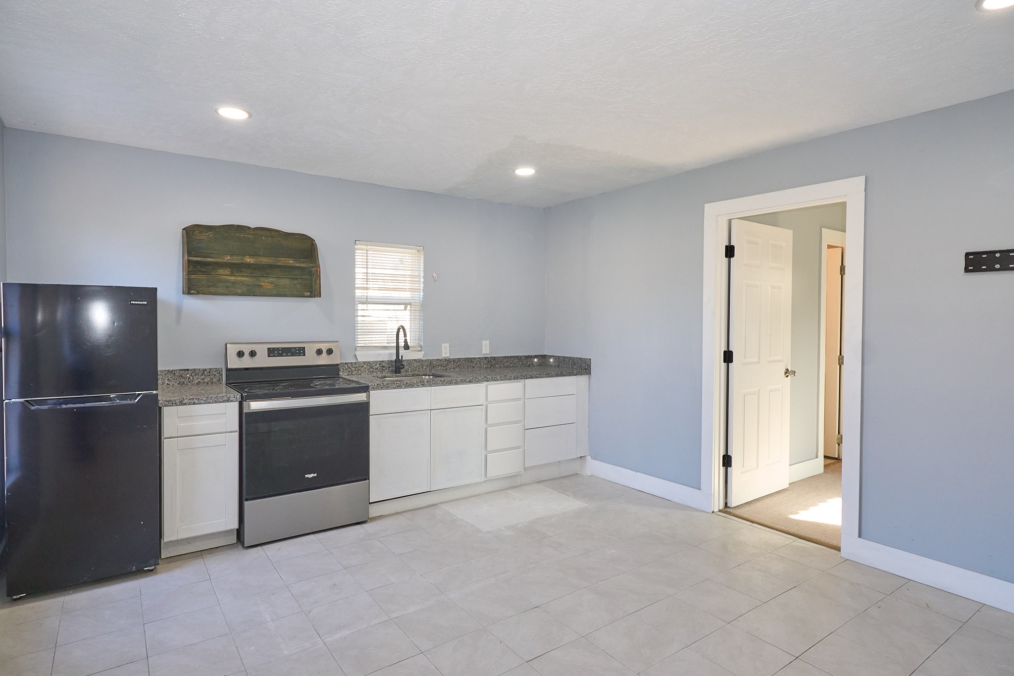 9010 Linda Vista Road Houston, TX 77078 - Photo 17 of 24 a kitchen with granite countertop a refrigerator and a stove top oven