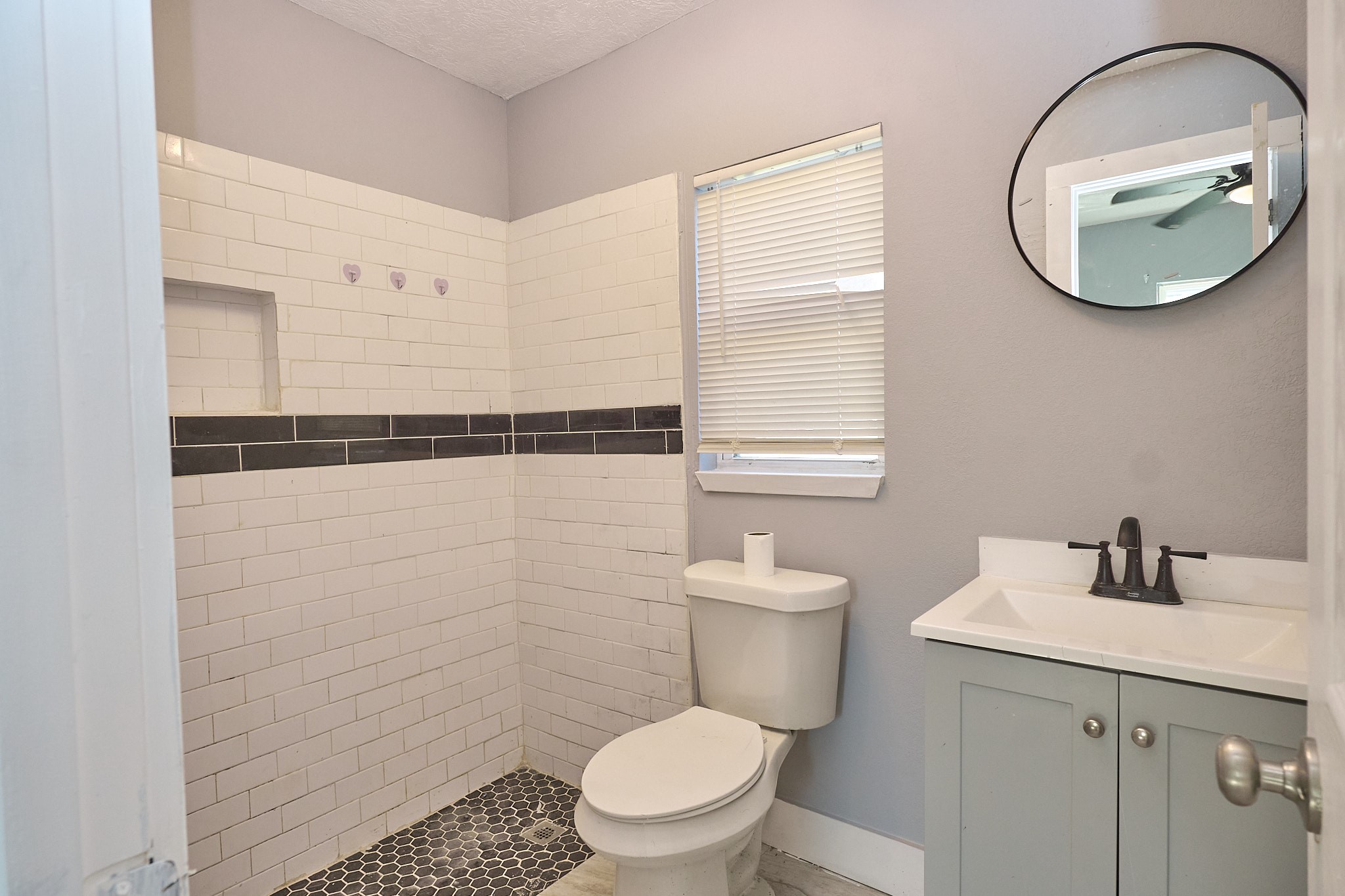 9010 Linda Vista Road Houston, TX 77078 - Photo 22 of 24 a bathroom with a toilet a sink and a mirror