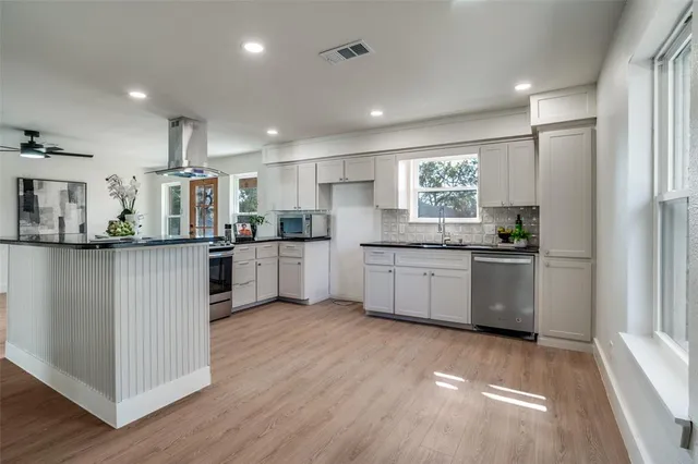 a kitchen with white cabinets and stainless steel appliances