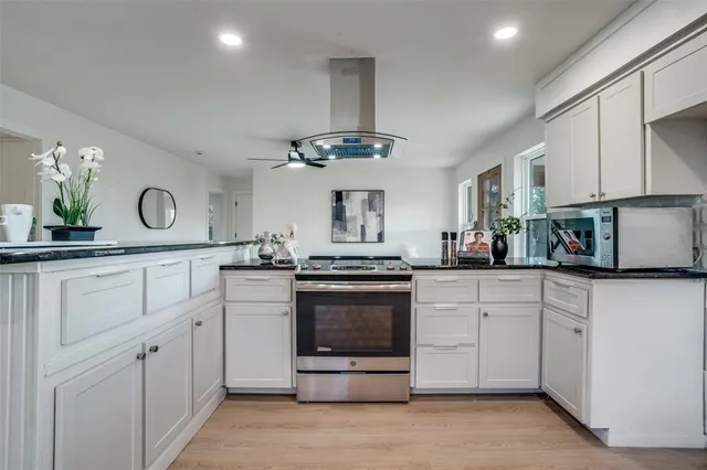 a kitchen with white cabinets and window