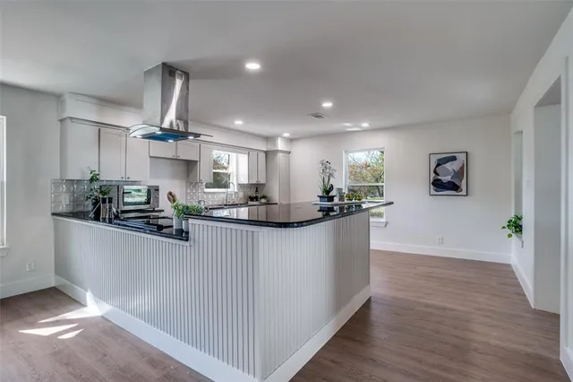 a kitchen with a sink cabinets and wooden floor