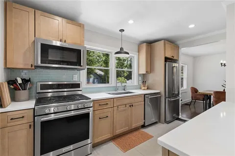 a kitchen with stainless steel appliances a stove refrigerator sink and microwave