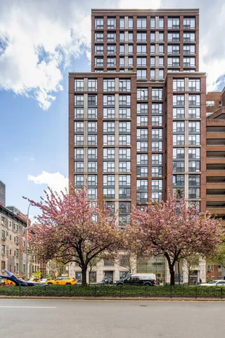 a front view of a building with lake view and trees