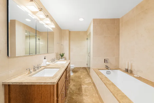 a bathroom with a tub sink and mirror