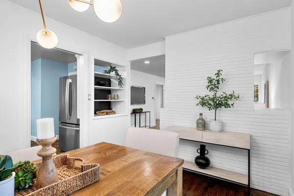 a bedroom with a bed and a potted plant on the dresser