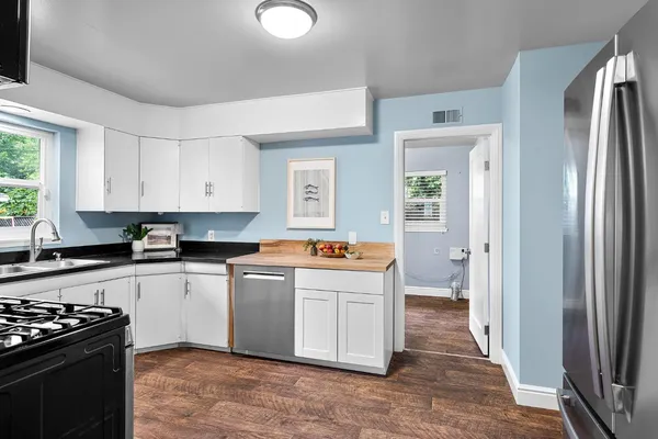 a kitchen with stainless steel appliances a stove a sink and a refrigerator