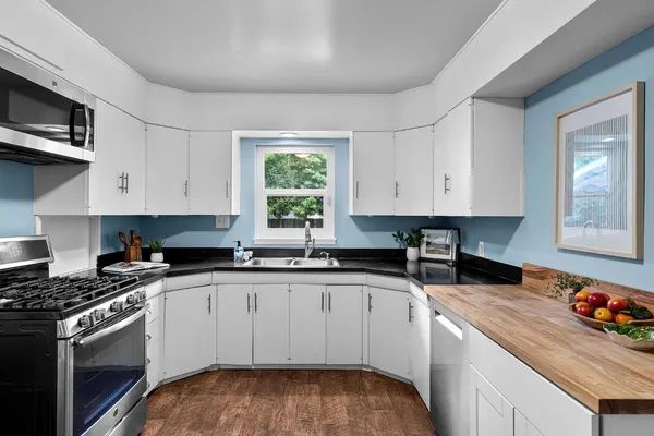 a kitchen with stainless steel appliances granite countertop a sink stove and cabinets