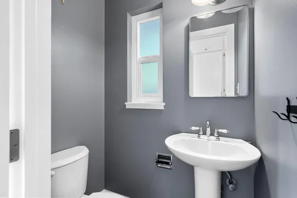 a bathroom with a sink a toilet and mirror