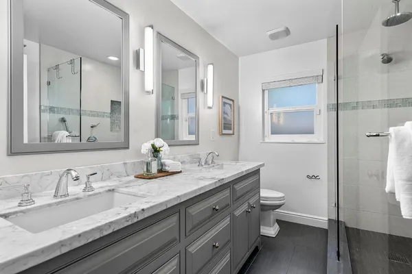 a bathroom with a granite countertop sink a toilet and a mirror