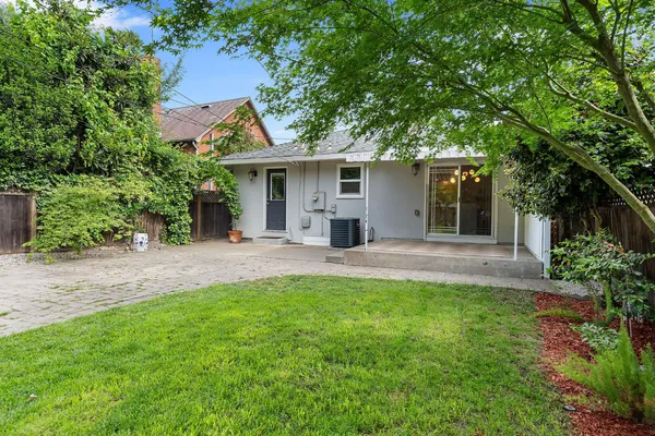 a view of a house with a yard and potted plants