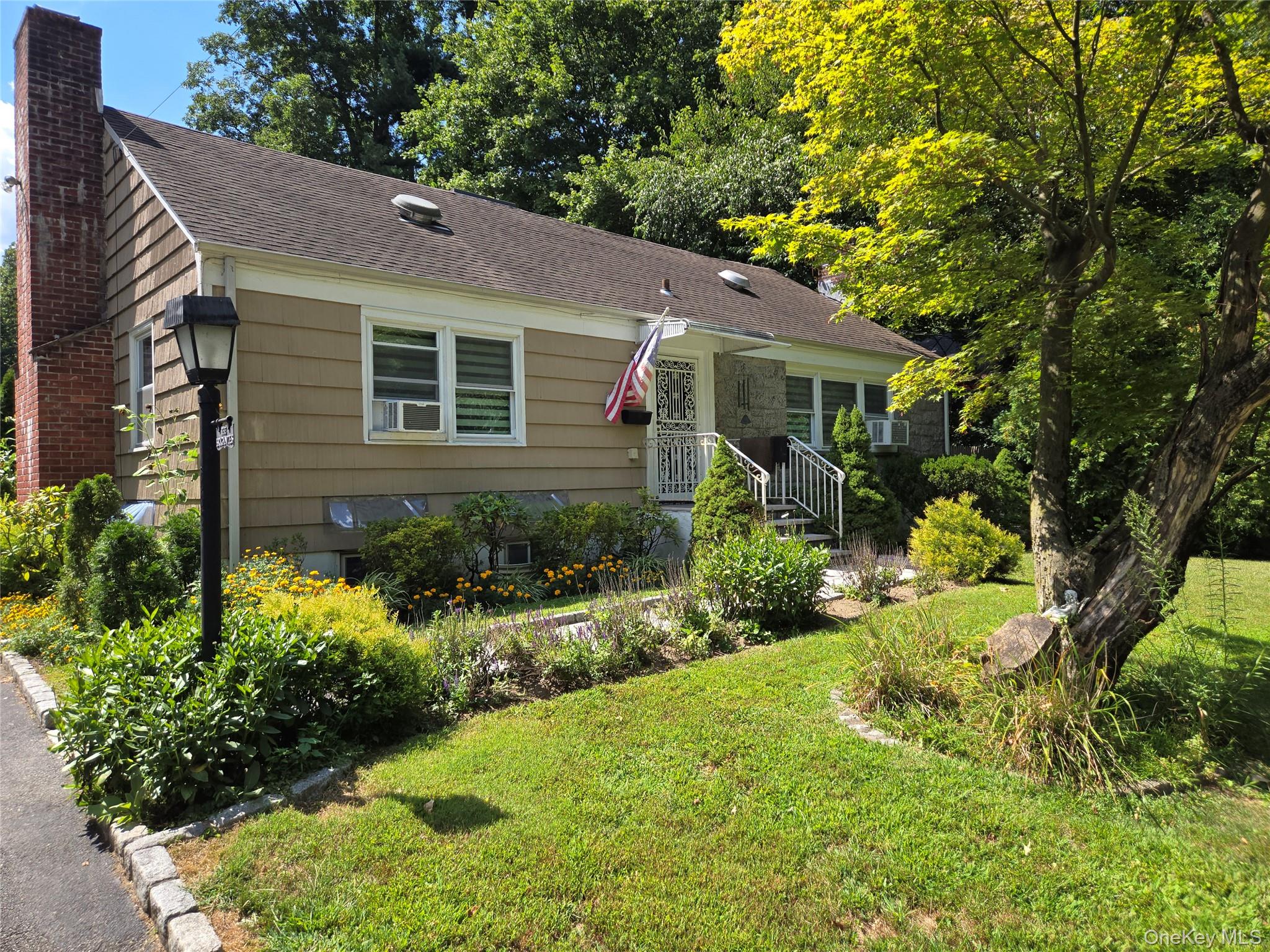 a view of a house with a yard and potted plants