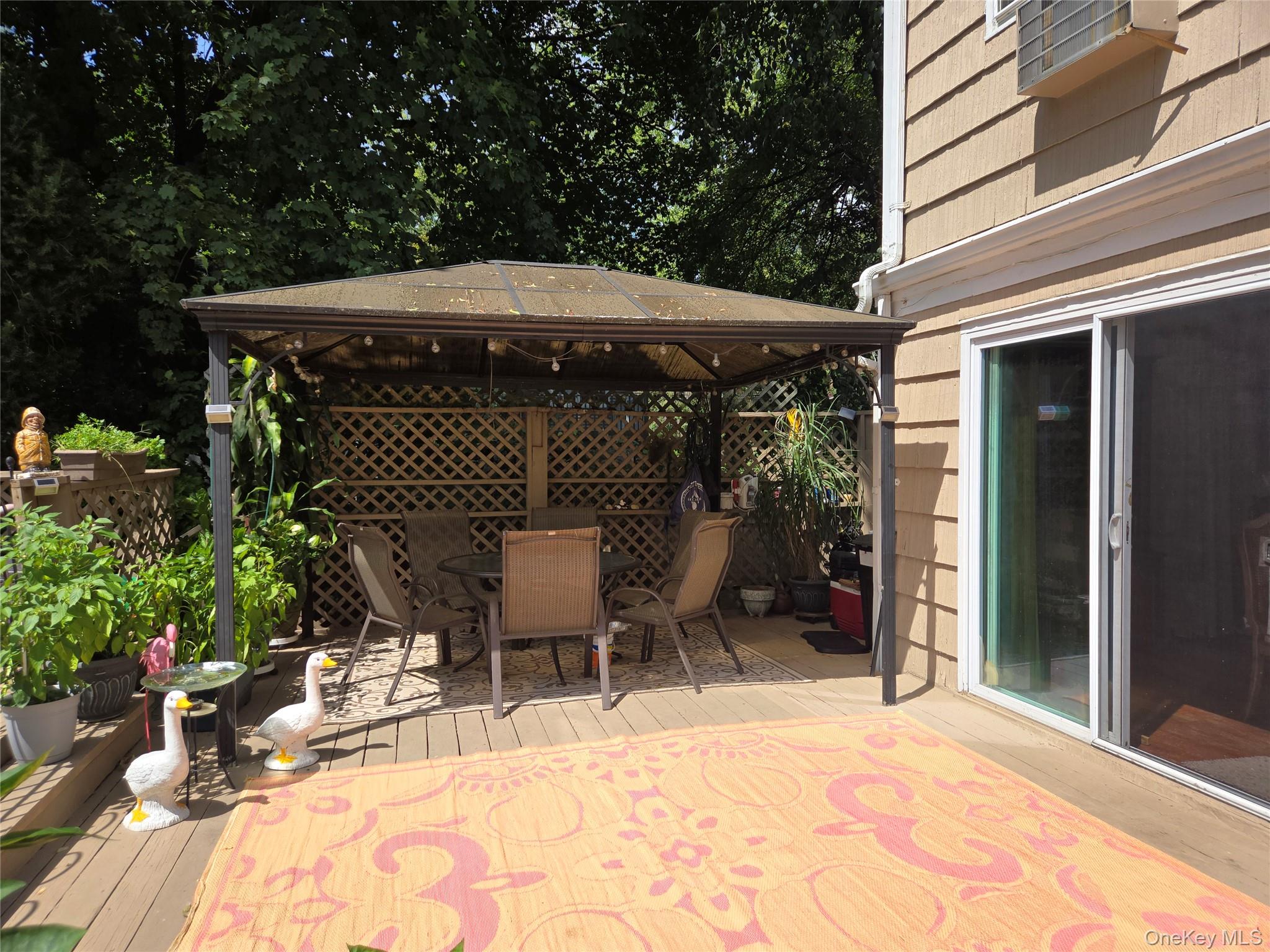 810 Fenimore Road Mamaroneck, NY 10543 - Photo 28 of 33 a view of a patio with table and chairs under an umbrella with potted plants