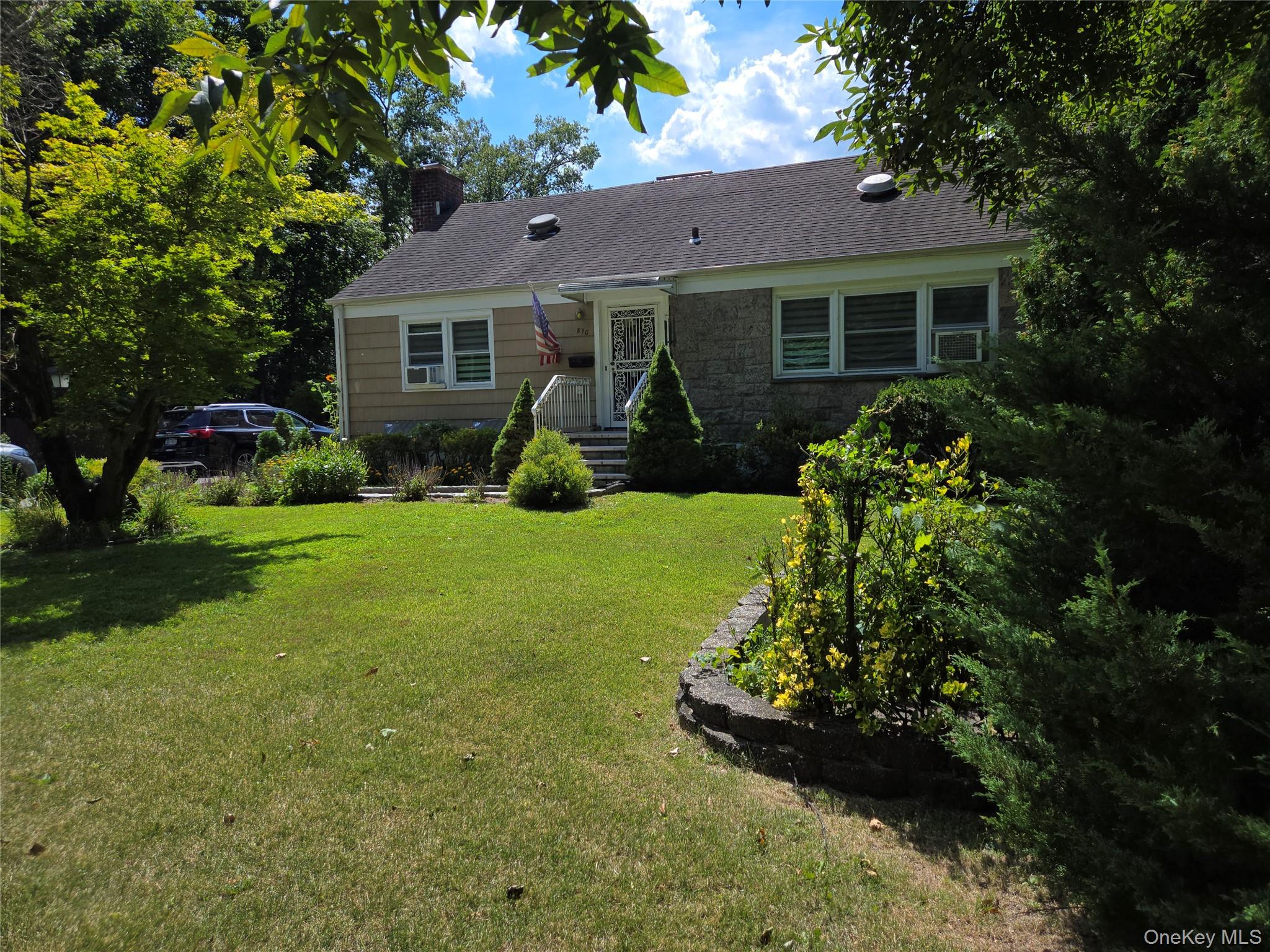 810 Fenimore Road Mamaroneck, NY 10543 - Photo 3 of 33 a front view of a house with a yard and garage