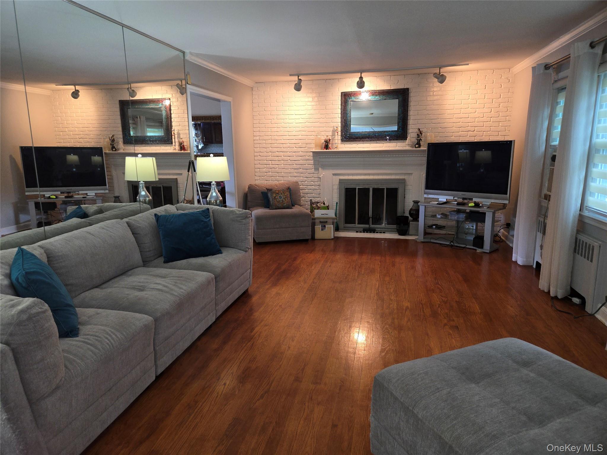 810 Fenimore Road Mamaroneck, NY 10543 - Photo 5 of 33 a living room with furniture a flat screen tv and a fireplace