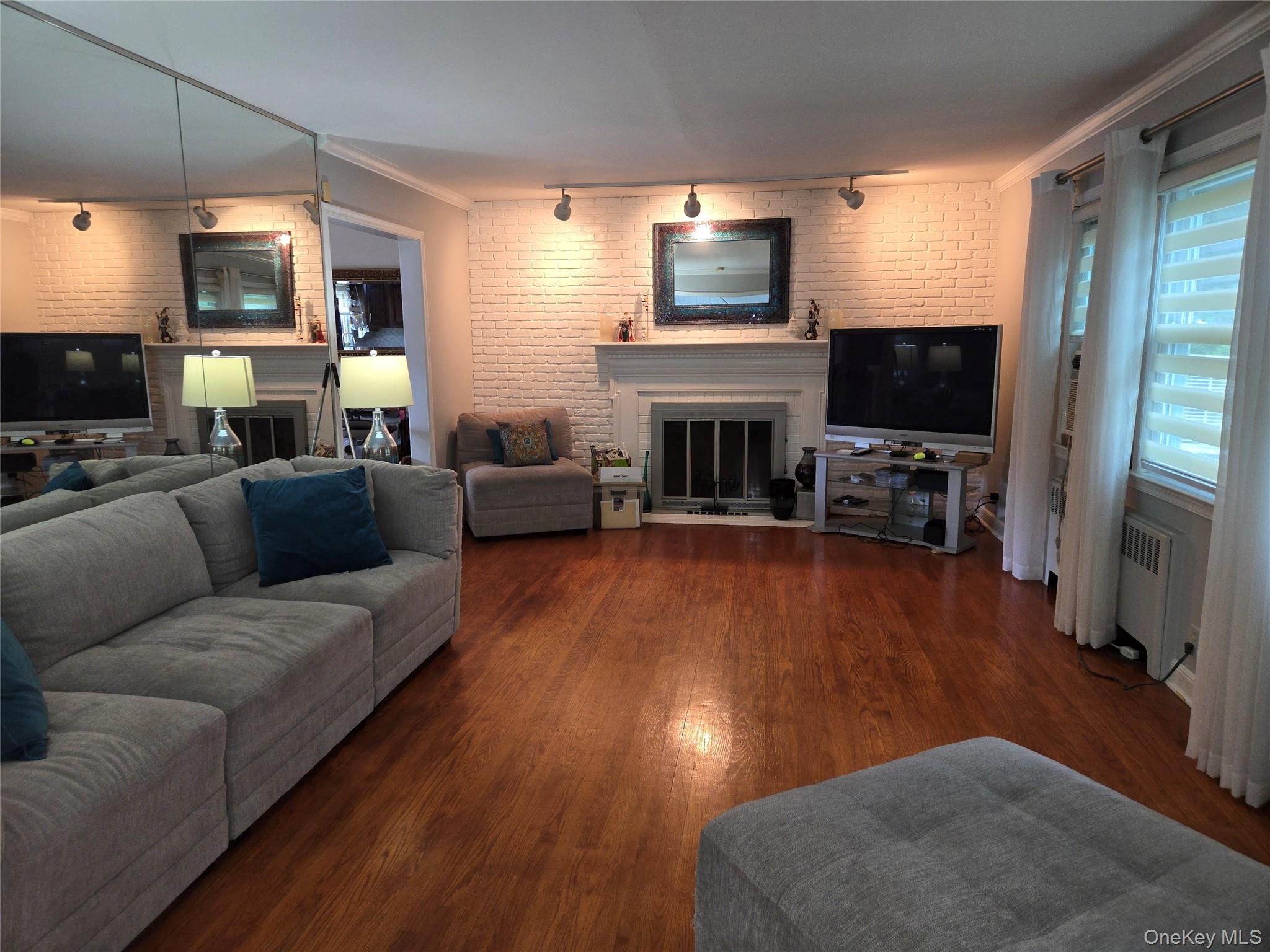 810 Fenimore Road Mamaroneck, NY 10543 - Photo 6 of 33 a living room with furniture a flat screen tv and a fireplace