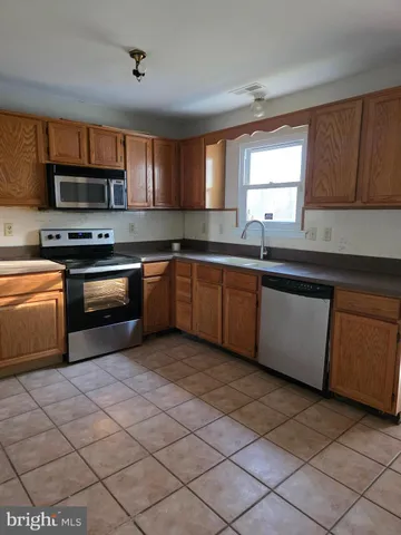 a kitchen with stainless steel appliances granite countertop a sink and a stove top oven