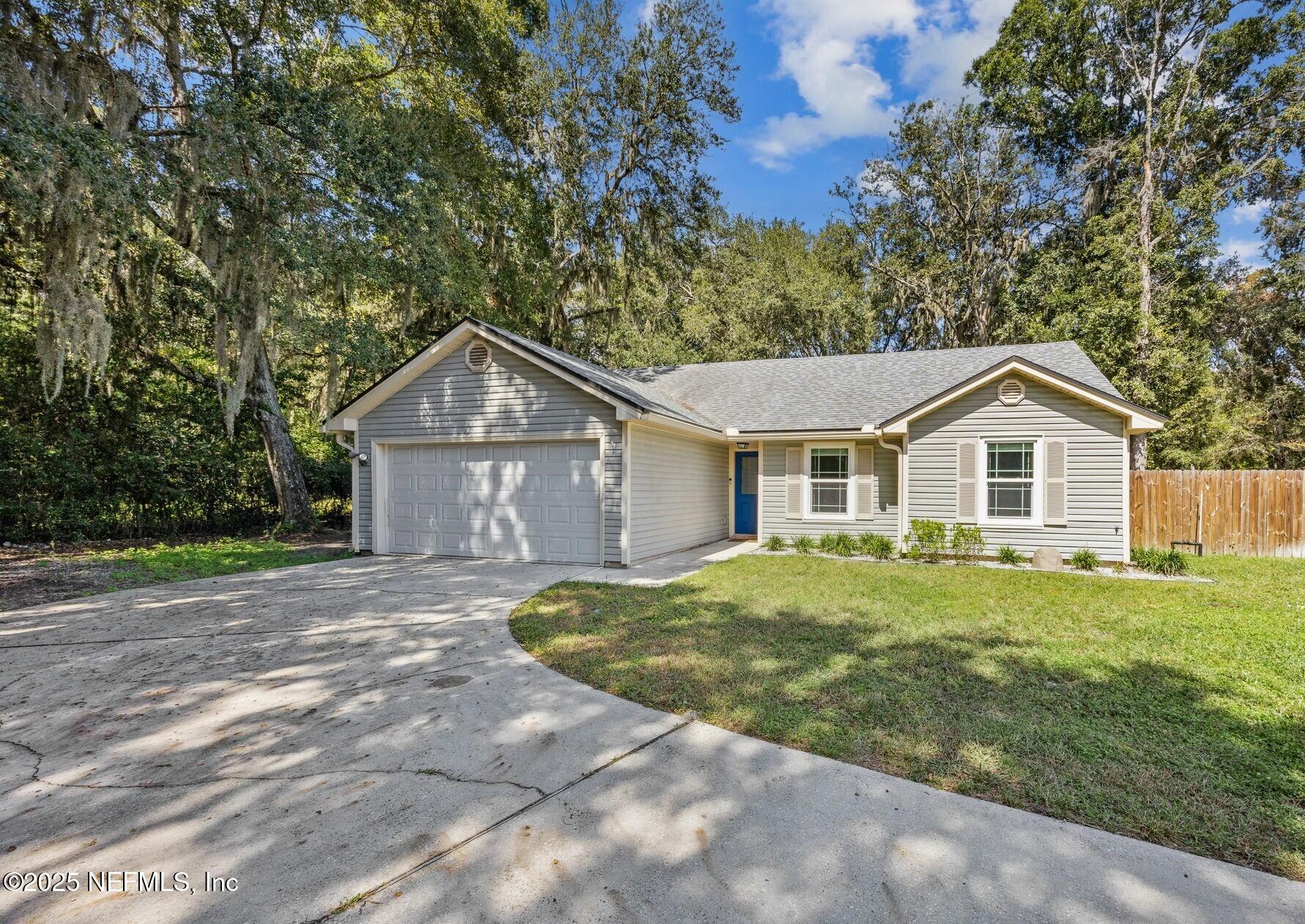 a front view of a house with a yard and trees