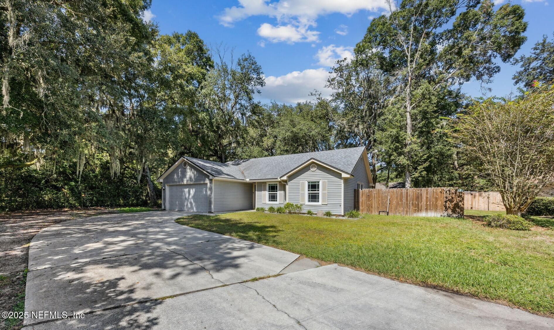 86001 Grant Place Yulee, FL 32097 - Photo 25 of 26 a front view of a house with a yard and trees