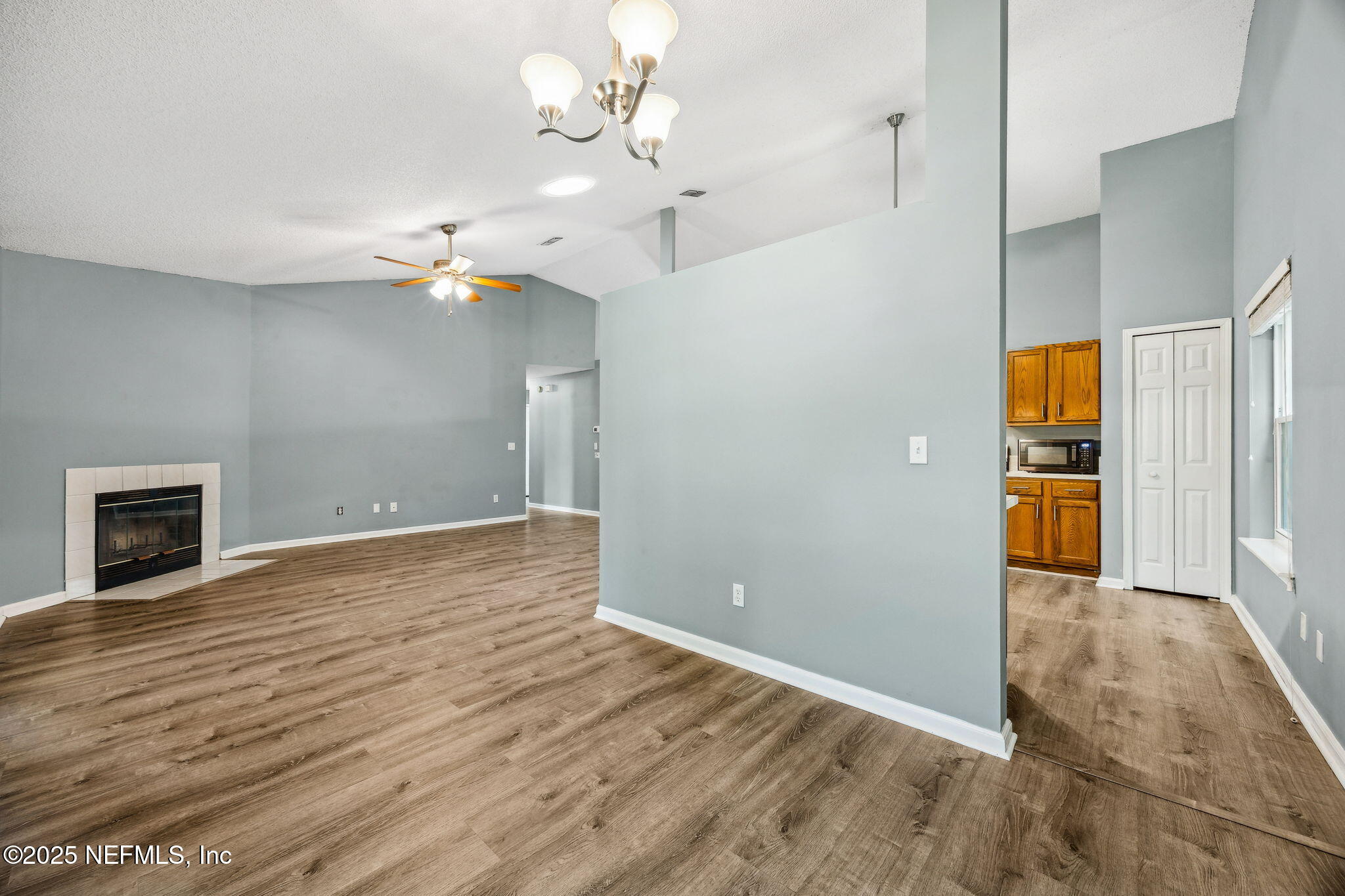 86001 Grant Place Yulee, FL 32097 - Photo 7 of 26 an empty room with wooden floor fireplace and staircase