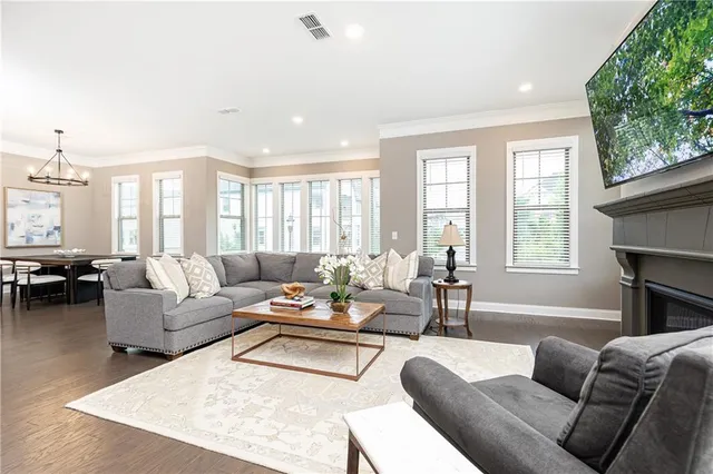 a living room with furniture fireplace and a large window