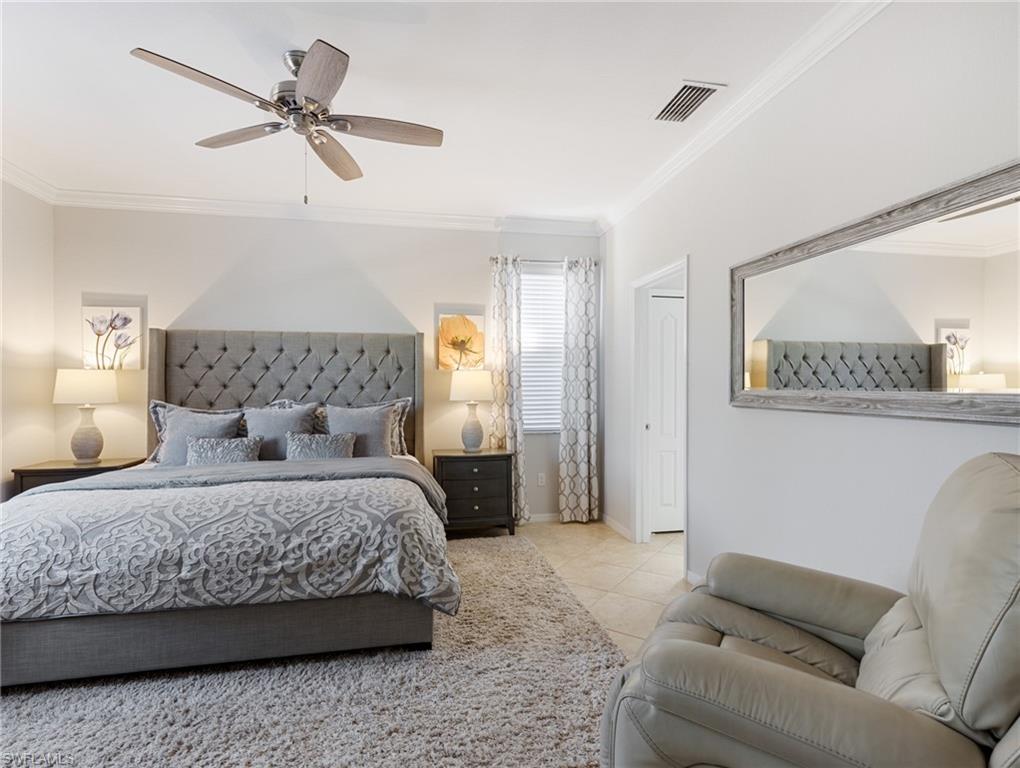 21116 Bella Terra Boulevard Estero, FL 33928 - Photo 20 of 49 a bedroom with a bed a couch and a chandelier
