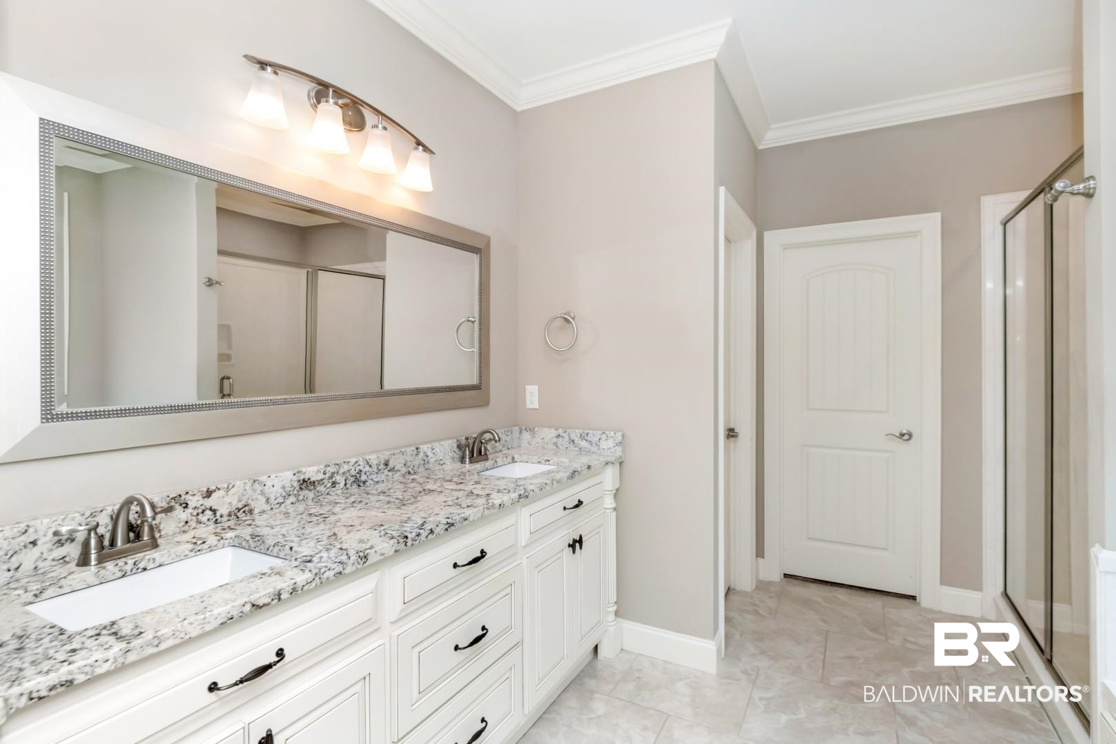 3528 Rue Royal Mobile, AL 36693 - Photo 25 of 53 Bathroom featuring a double vanity with white cabinetry and dark hardware, dual undermount sinks, and a speckled countertop