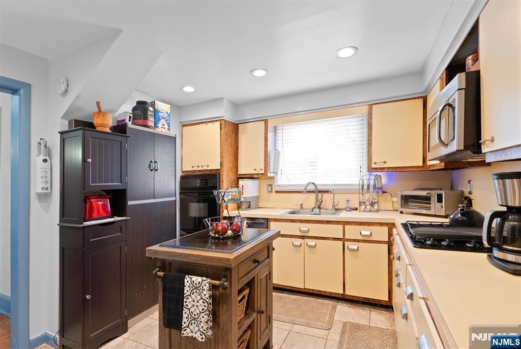 276 East 26th Street Paterson, NJ 07514 - Photo 11 of 30 a kitchen with a sink cabinets and appliances