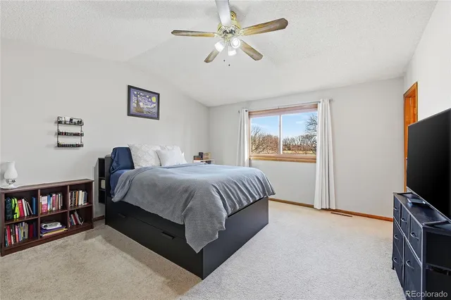 a spacious bedroom with a bed a dresser and a book shelf