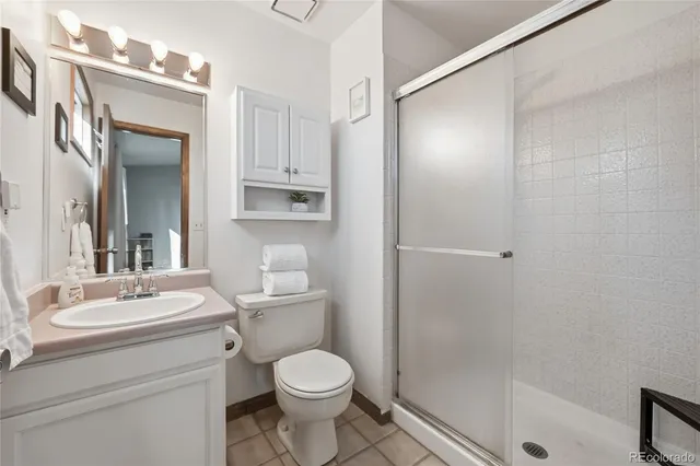 a bathroom with a toilet a sink a mirror and shower