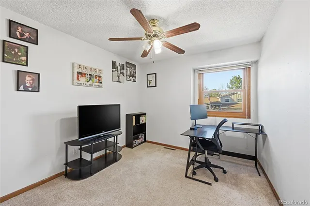 a work room with furniture and a ceiling fan