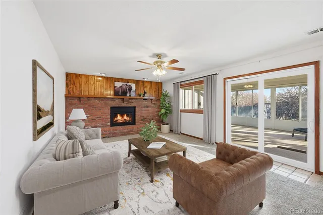 a living room with furniture a fireplace and a large window