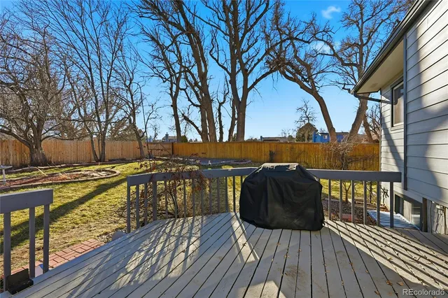 a view of balcony with wooden floor and large trees