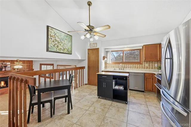 a kitchen with stainless steel appliances granite countertop a refrigerator a stove a sink a oven with a dining table and chairs