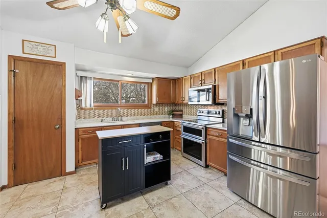 a kitchen with stainless steel appliances granite countertop a refrigerator a stove a sink and dishwasher
