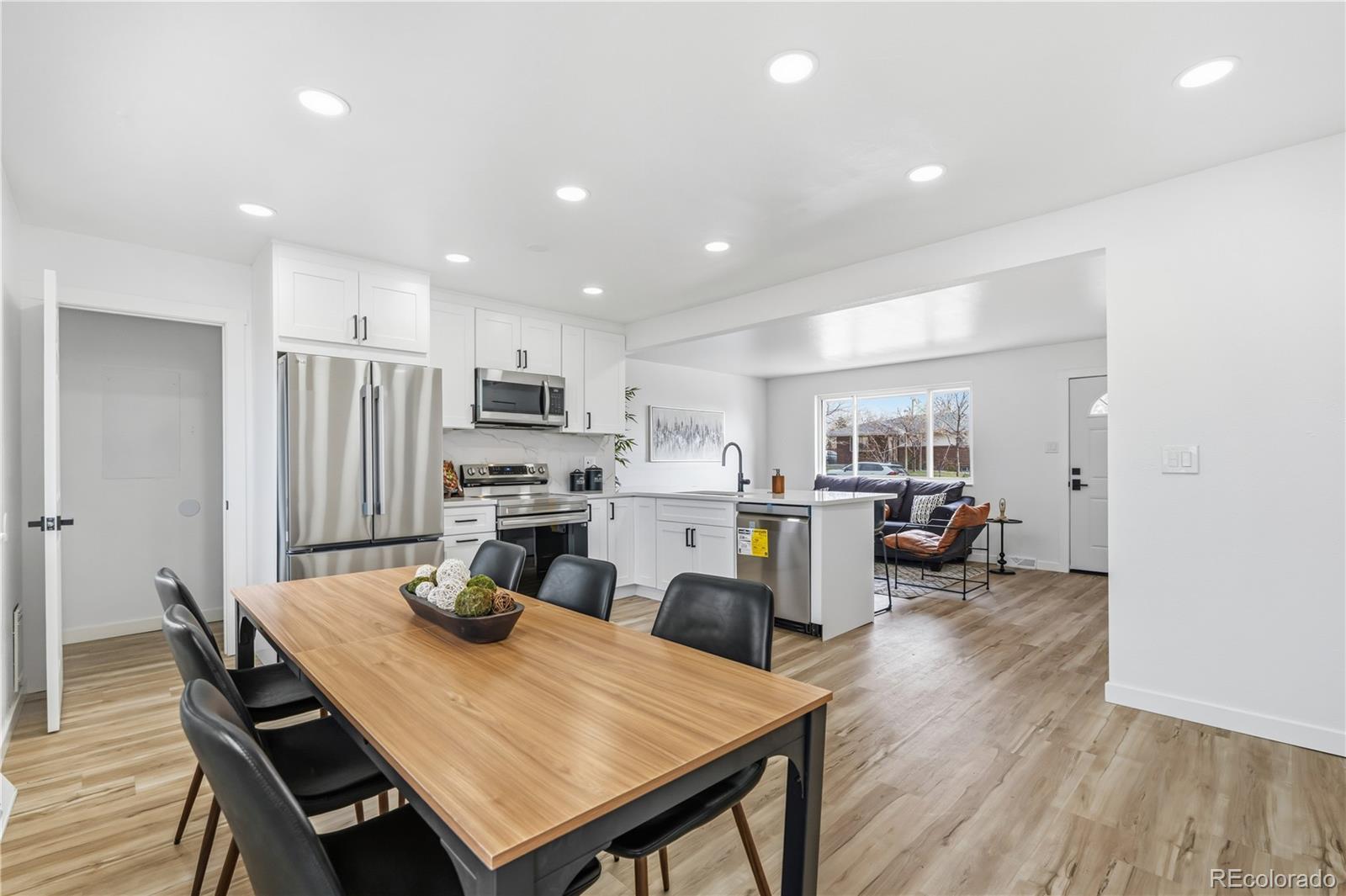 8331 Ogden Street Denver, CO 80229 - Photo 6 of 23 a kitchen with sink cabinets and wooden floor