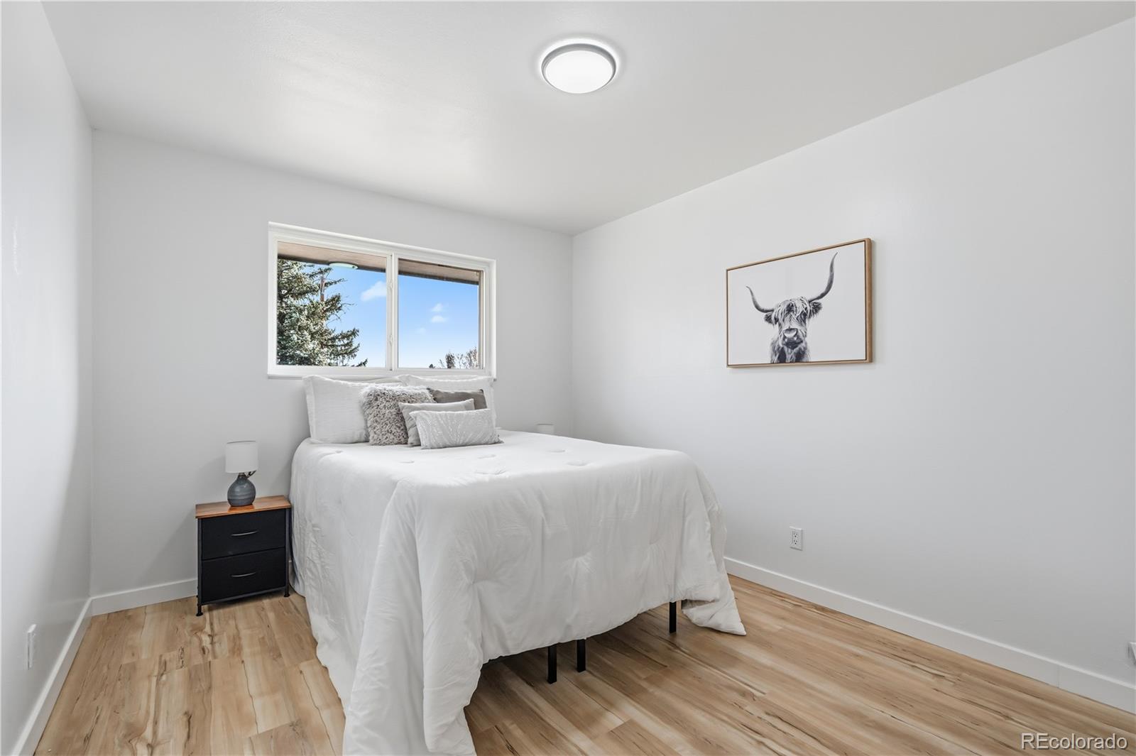 8331 Ogden Street Denver, CO 80229 - Photo 7 of 23 a bedroom with a bed and a painting on the wall