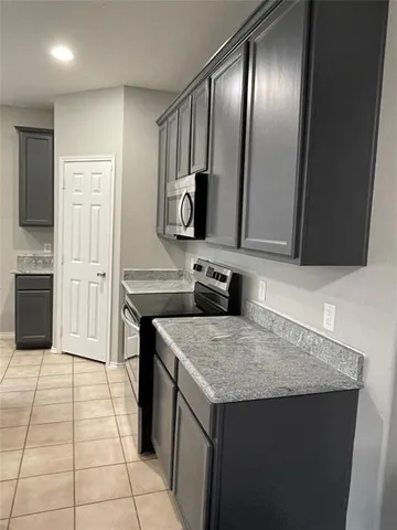 a kitchen with a sink refrigerator and microwave