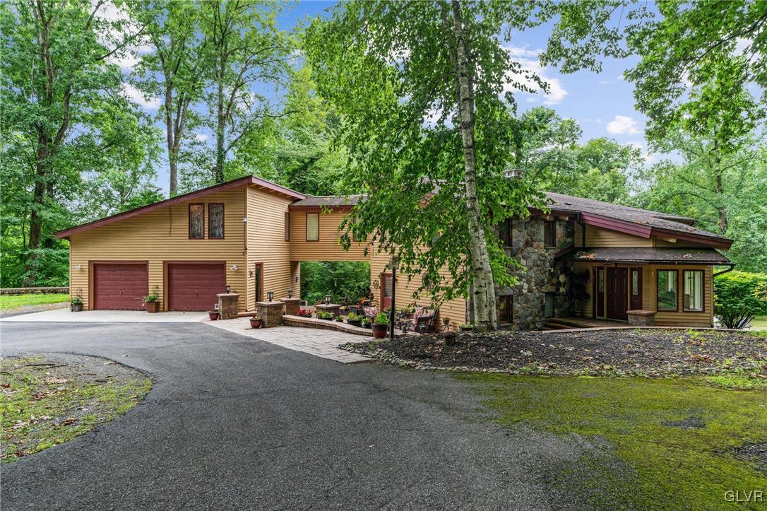 a view of a house with backyard and trees