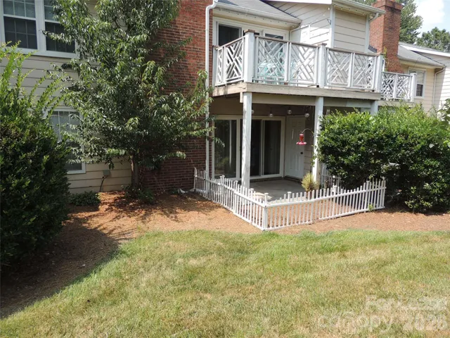 a view of a house with a yard and large tree