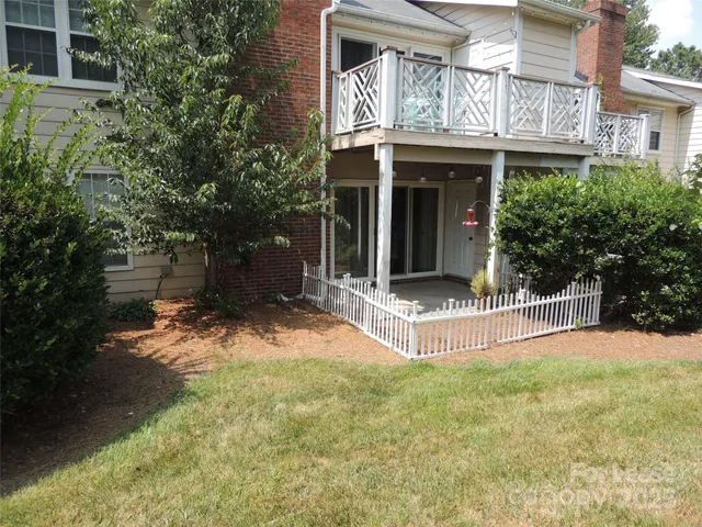 a view of a house with a yard and large tree