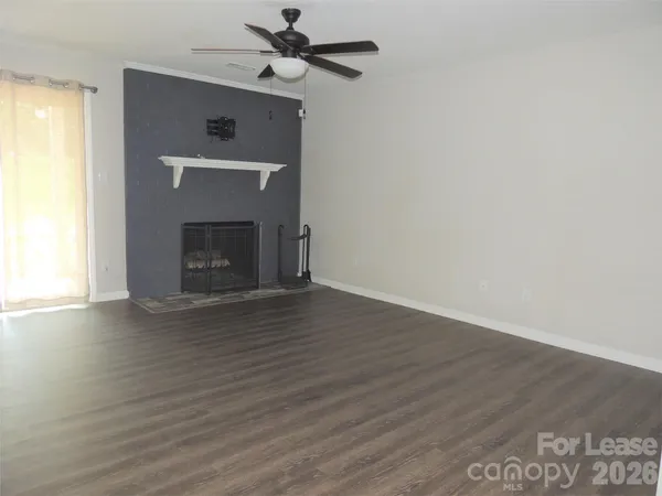 a view of empty room with wooden floor and fireplace