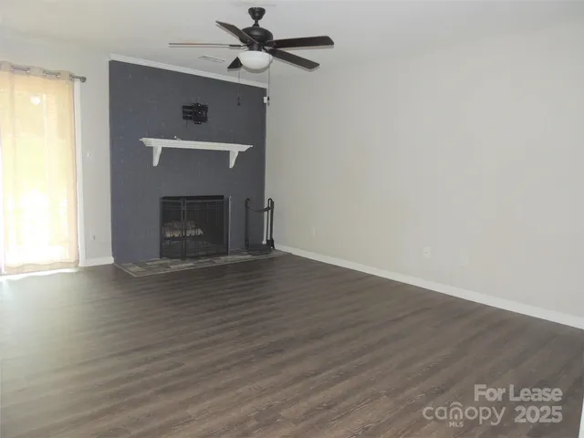 a view of empty room with wooden floor and fireplace