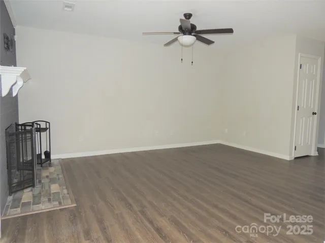 a view of a room with wooden floor and ceiling fan
