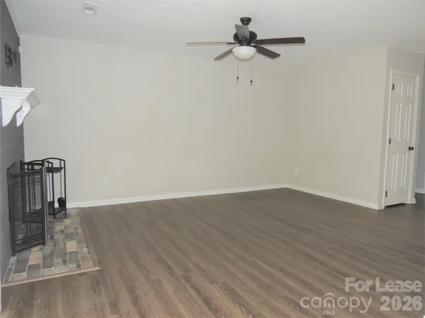 a view of a room with wooden floor and ceiling fan